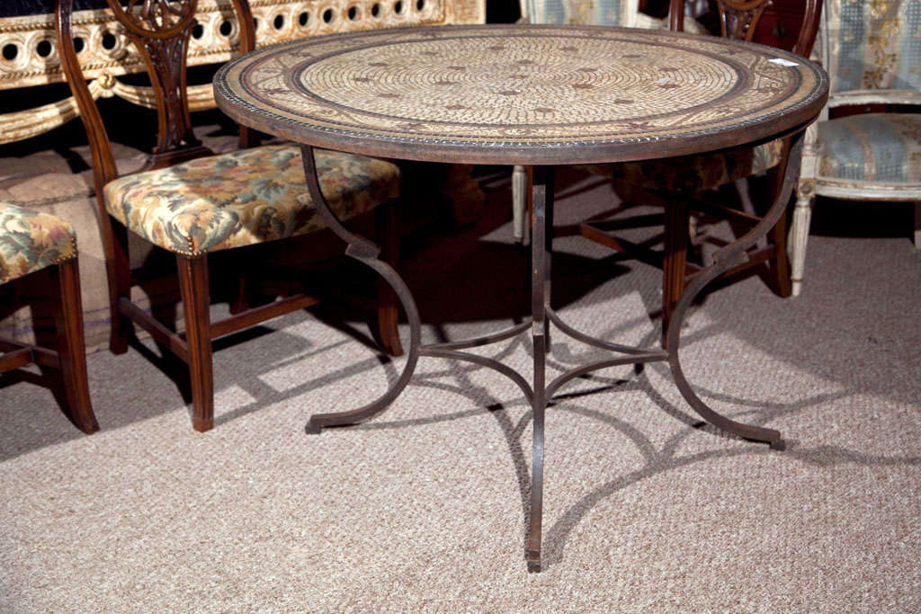 A circular mosaic tile top iron base center or dining table for the garden.