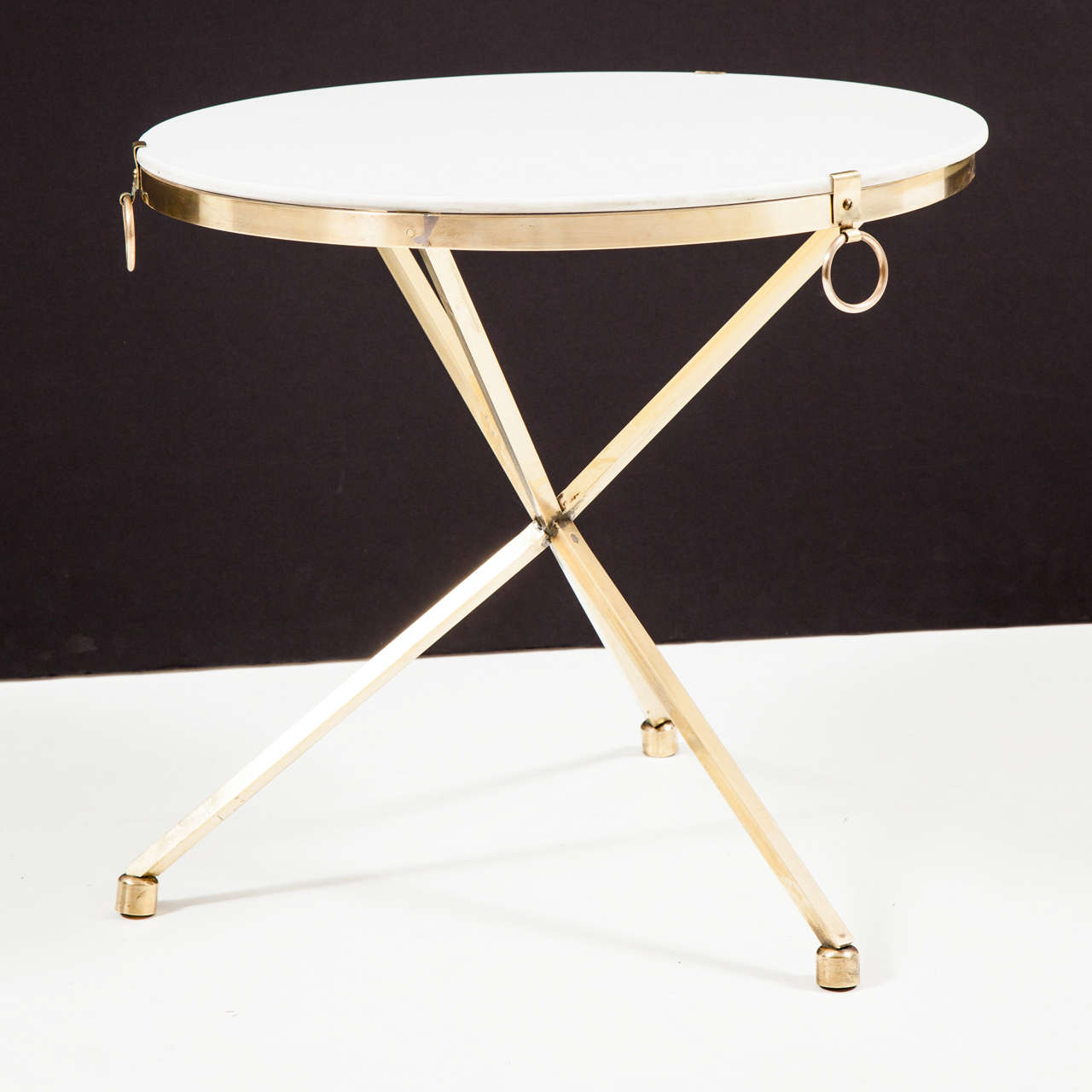 Hand-forged brass tripod table supports an opaque whie glass top. American, ca 1950. New polished, otherwise original condition. 

This item can be seen at our showroom, 1stDibs@NYDC, 200 Lexington Ave, Tenth Floor.