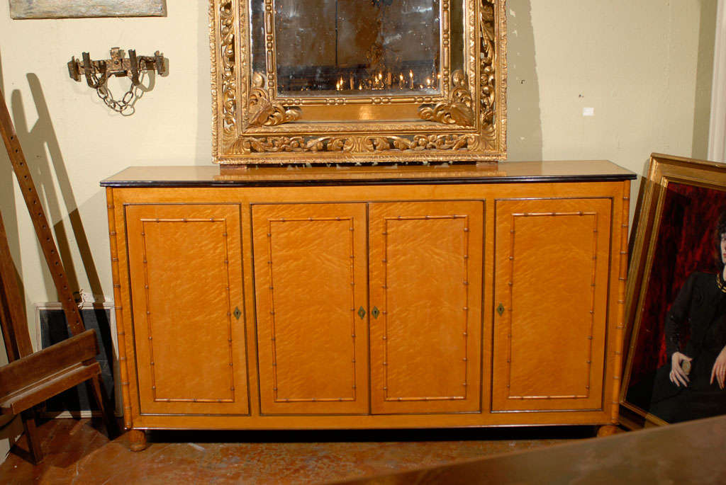 An elegant long, narrow sideboard with delicate Asian inspired faux bamboo detailing was created out of exquisite tiger maple in France during the late 19th Century. This remarkable French antique has room to store a myriad of things.