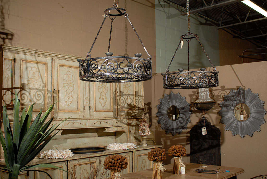 A pair of wrought iron Gothic style basket chandeliers from early 20th Century France can be used with candles or wired for electricity.  The Gothic or Moorish design will create an aura of mystery in any rustic setting.