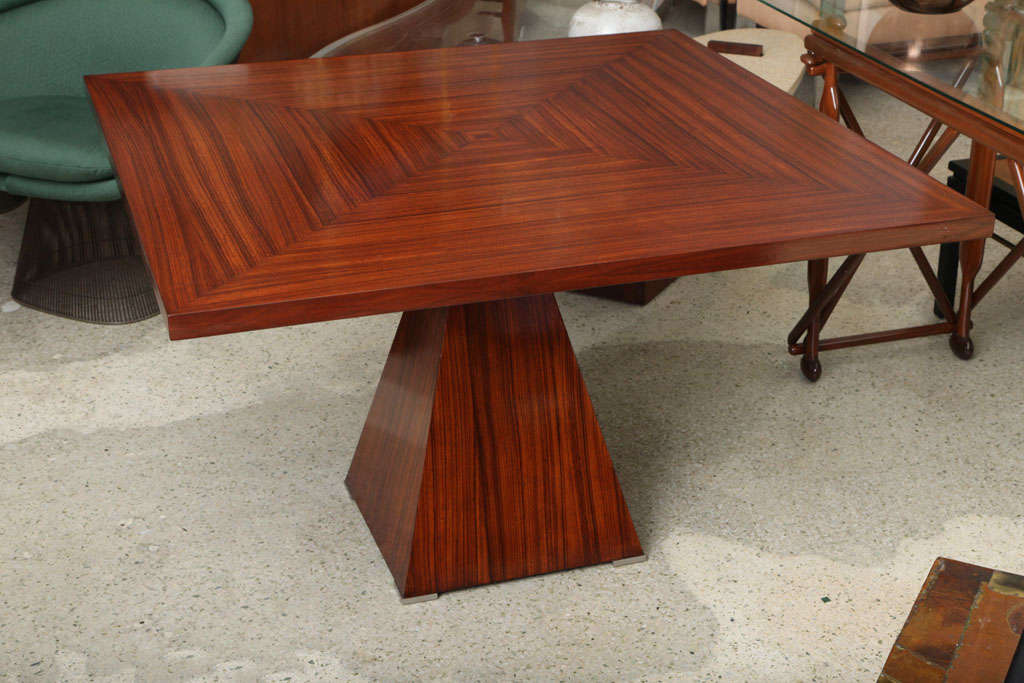 The square table veneered au quatre face, above a single pedestal with pyramidal shape with stainless banding.