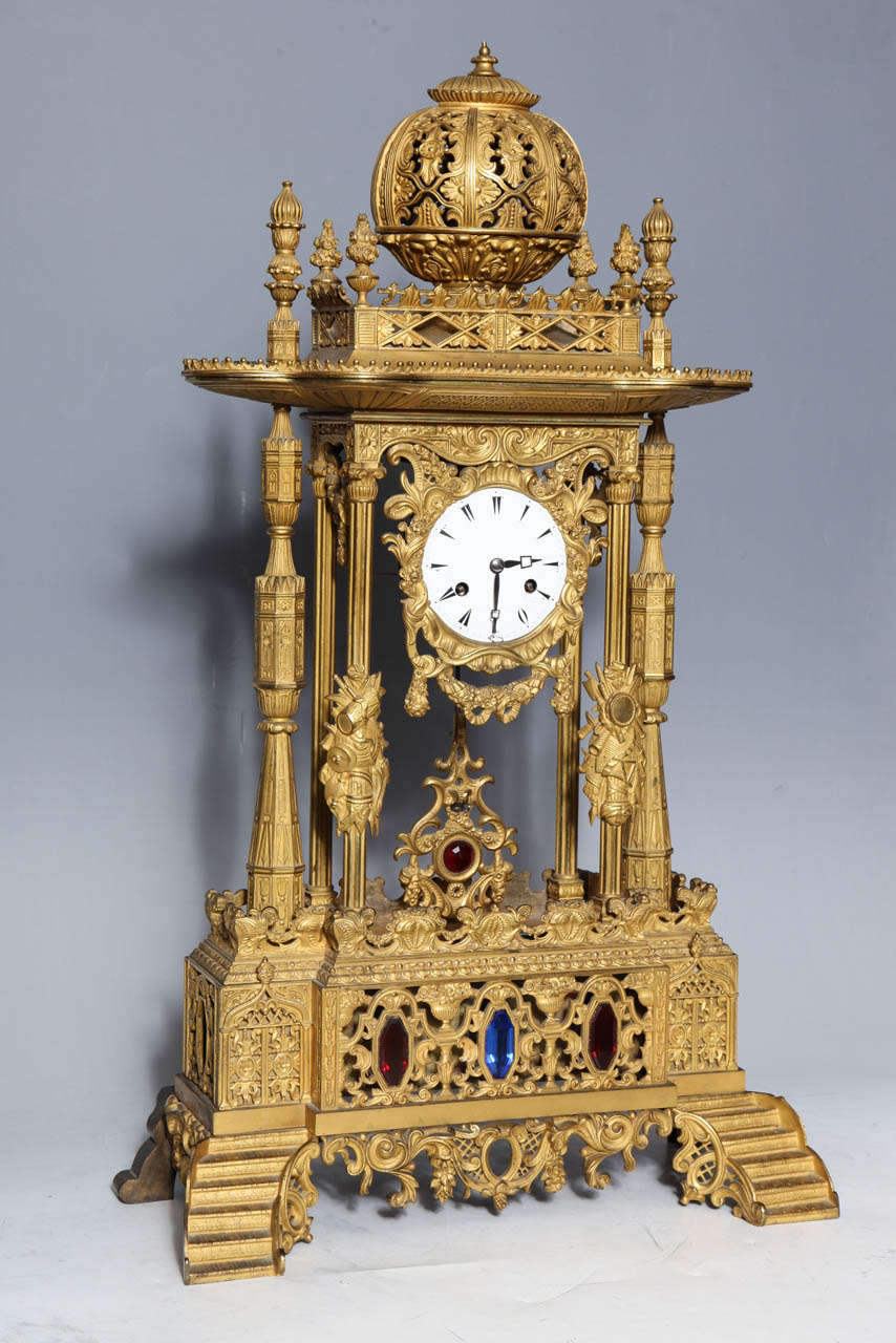 An important antique French orientalist style Jeweled gilt bronze clock made for the Ottoman market. This enameled clock sits within the decorated column's supporting a tulip shaped dome. Swags and wreaths abound, culled from many periods, while