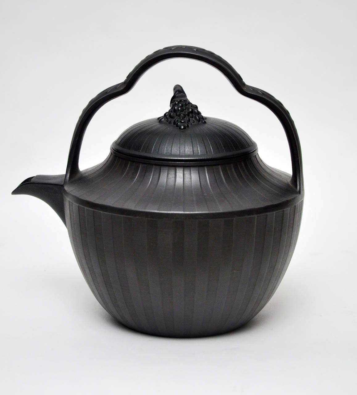 Charmante bouilloire en basalte de Wedgwood dont le couvercle est orné d'un motif en forme de ruban imprimé sur toute sa surface. Grappe de raisin pour la finale sur le couvercle. Signé Wedgewood.