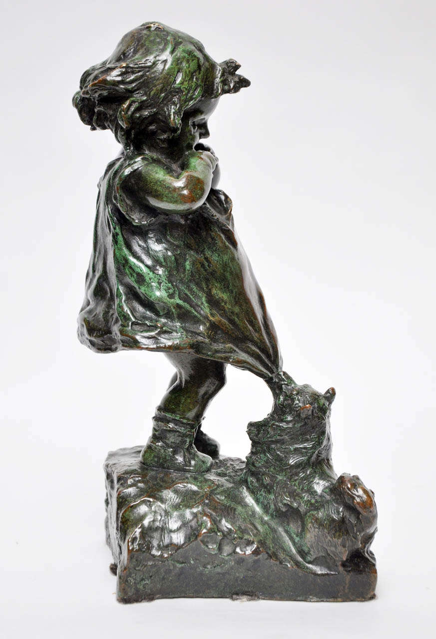 Charming Art Nouveau inspired bronze figurine of a young girl with outstretched hands holding a cookie, while a small dog pulls at her dress, begging to share. Signed Juan Clara with foundry marks.