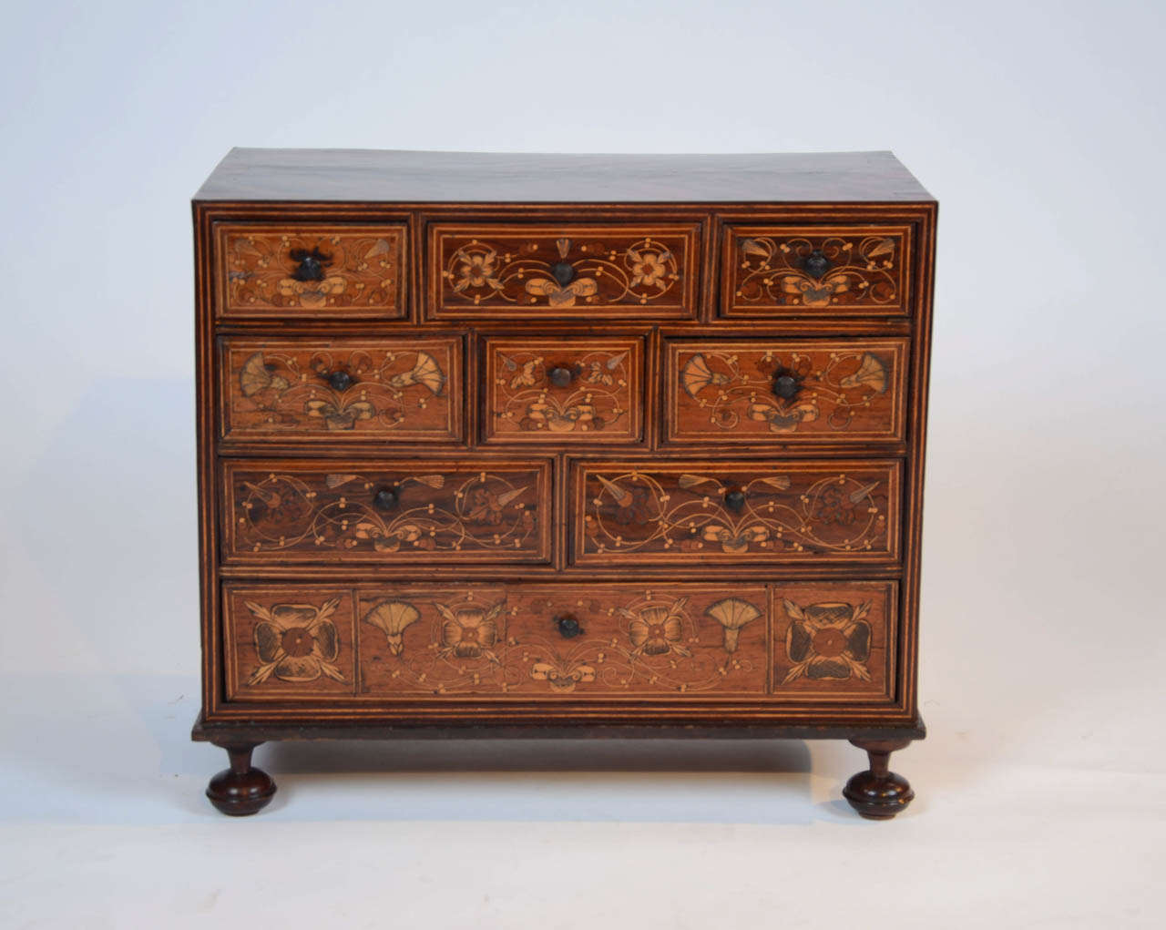 A wonderful early 17th century Portuguese miniature chest of drawers with saw cut and engraved marquetry work to the drawer fronts. The sides and top with fine mahogany veneers and coromandel cross banding.