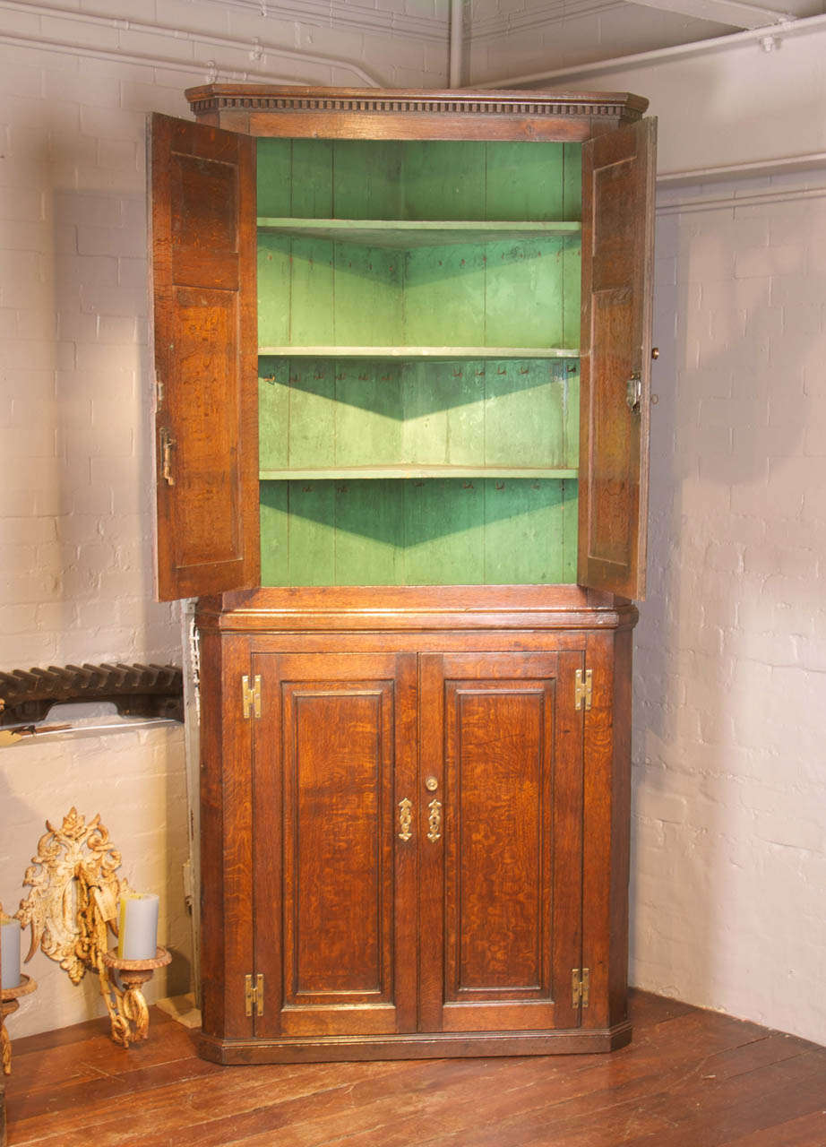 A fine George III period oak corner cupboard; the upper and lower part with panelled doors opening to a painted interior and fixed shelves.
Working locks and keys.