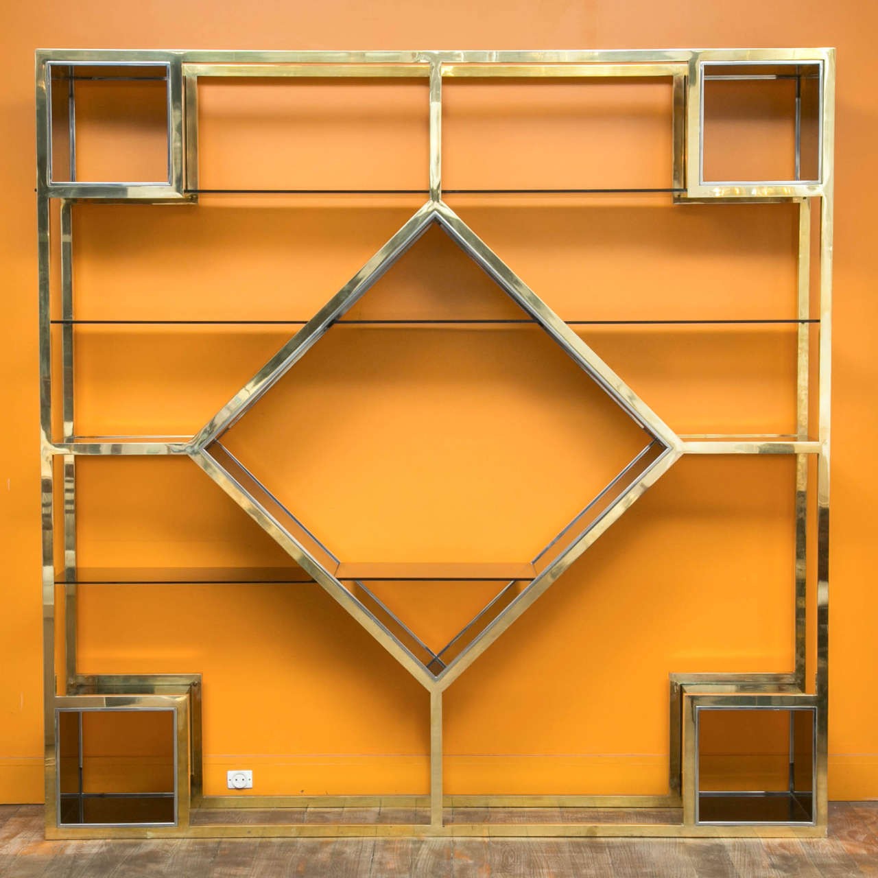 A large metal étagère, polished brass structure, partly chromed.
12 colored glass shelves of various sizes,
one large colored Lucite compartment in the centre and four at the angles.
Romeo Rega, Italy, circa 1970.