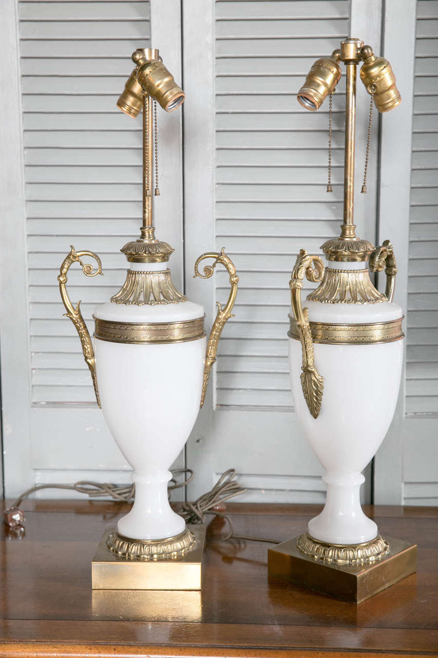 A pair of French opaline glass table lamps with bronze fittings, circa 1920s.