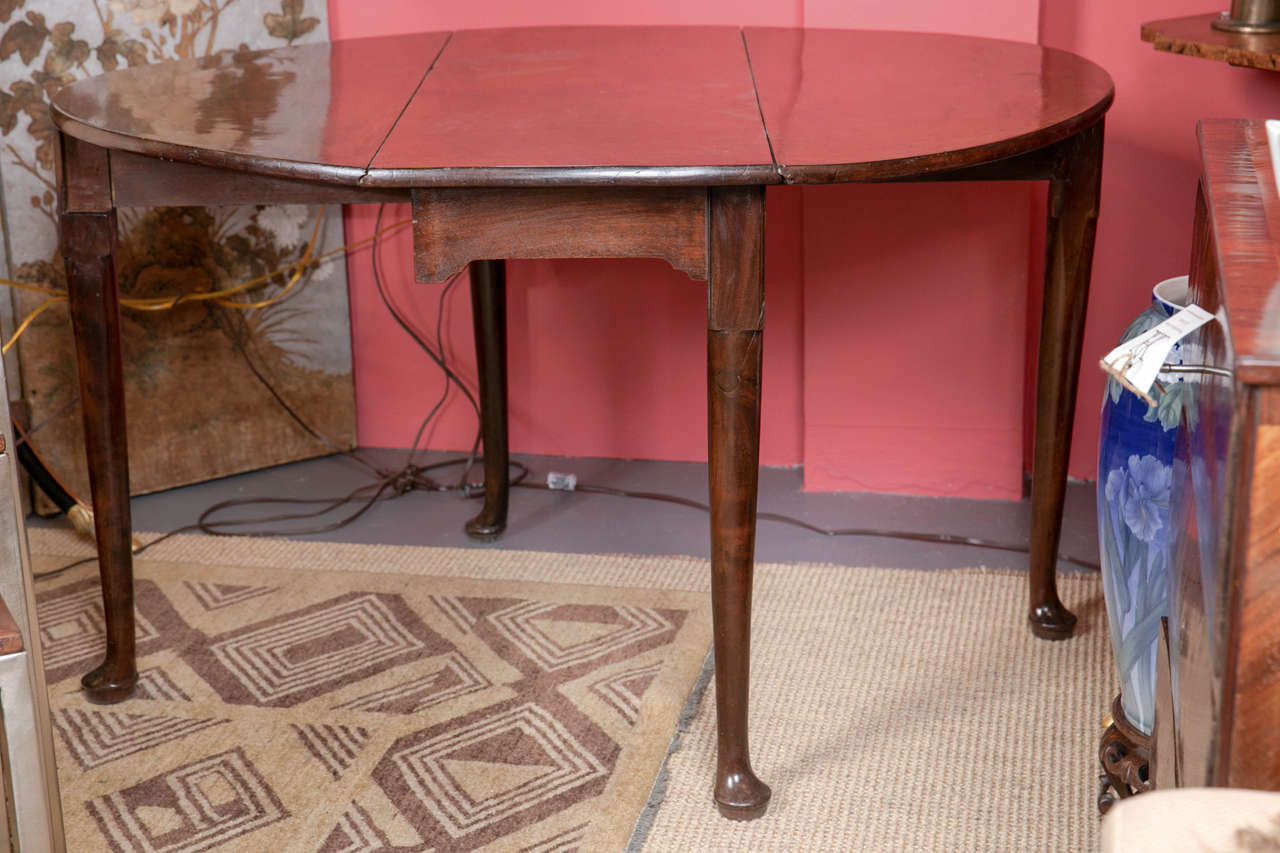 A mahogany Queen Anne drop leaf table, with turned, tapered legs. English c. 1740.