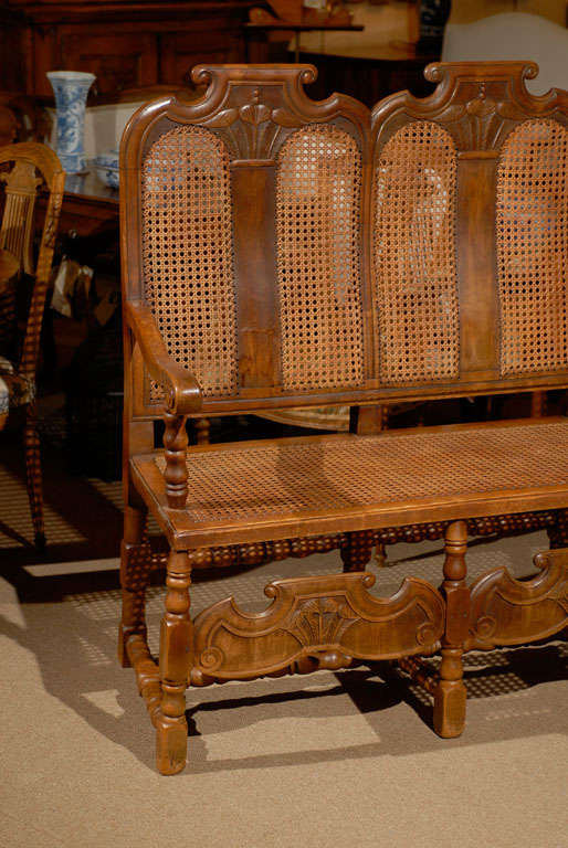A Dutch triple back caned bench in walnut with carved feather plume deign, turned stretcher and legs, France 1850. Also has a new muslin cushion not shown in photographs.

For many more fine antiques, please visit our website.

William Word Fine