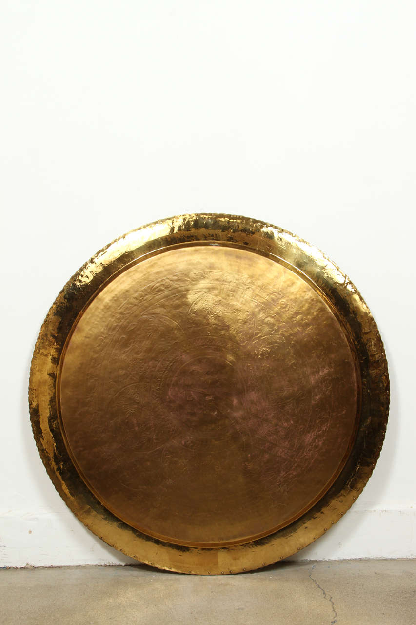 Mid-Century Chinese imports polished brass tray, finely hammered and chiseled, engraved with scenes of wild animals and foliage.
Moroccan brass tray, polished in front and back. Could be used as a tray table or hang on the wall, has a hook in the