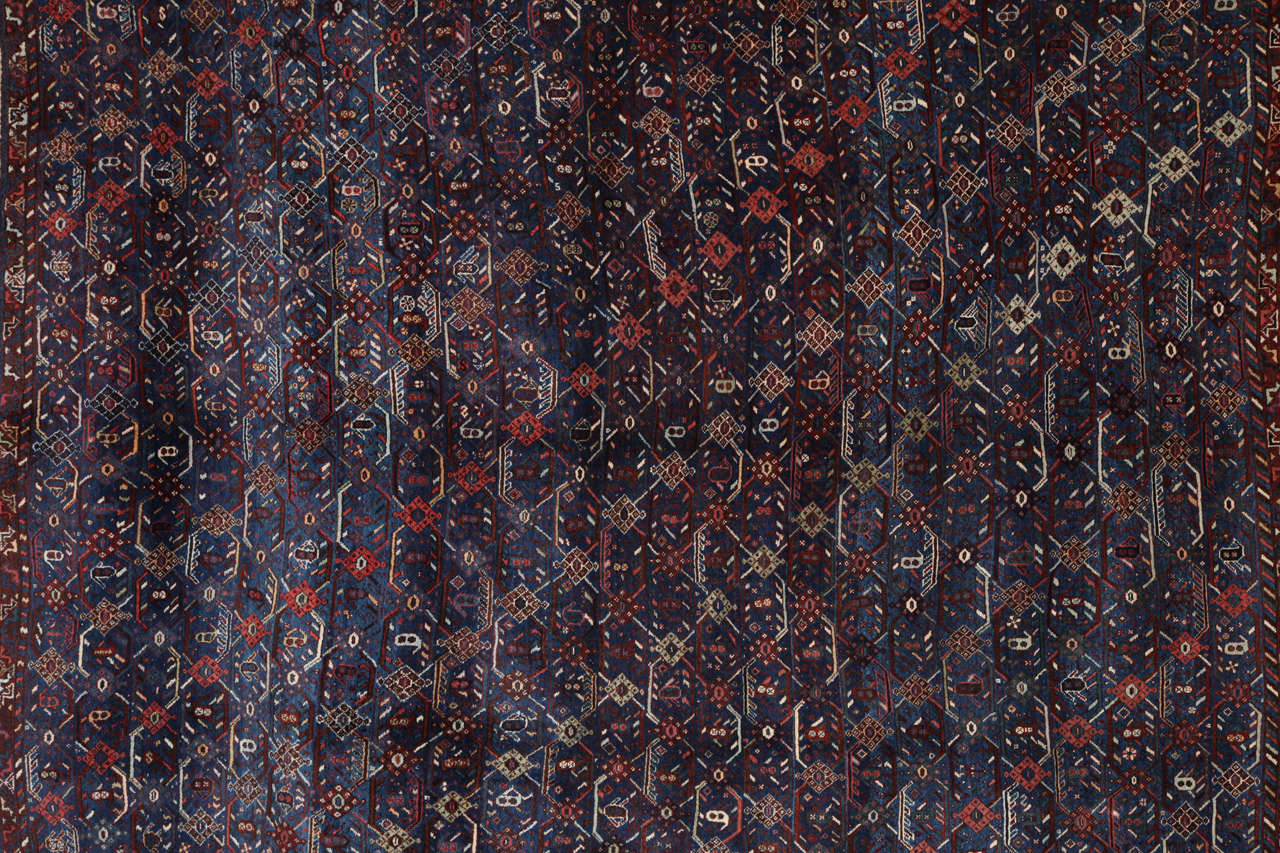 This Persian Qashqai carpet circa 1880 consists of a pure handspun wool warp, weft and hand-knotted pile and natural vegetal dyes. Its rather unique and detailed geometric design exhibits colors of rich blue, navy, red and cream. The size is 7'1