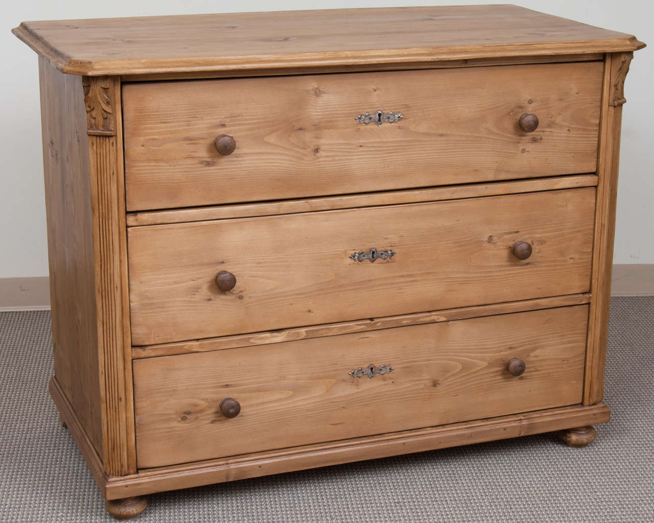 A beautiful chest of light honey colour featuring three generous hand-cut dovetailed drawers flanked by chamfered corners bearing reeded molding and corbels.