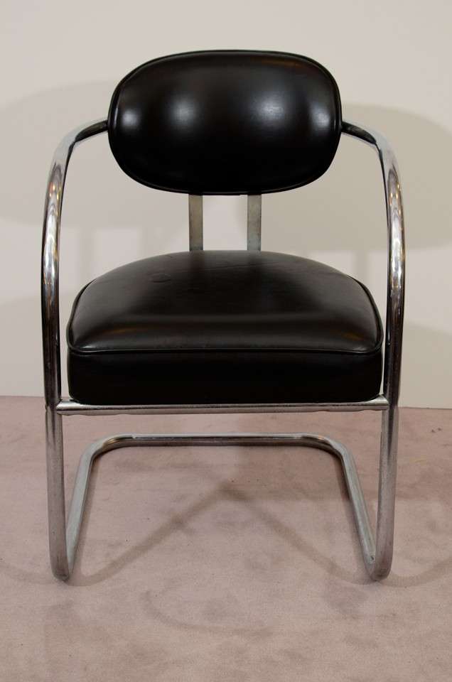 A pair of vintage armchairs with tubular chrome frames and black vinyl cushions. They are in good vintage condition with age appropriate wear; some wear/scratching to vinyl.