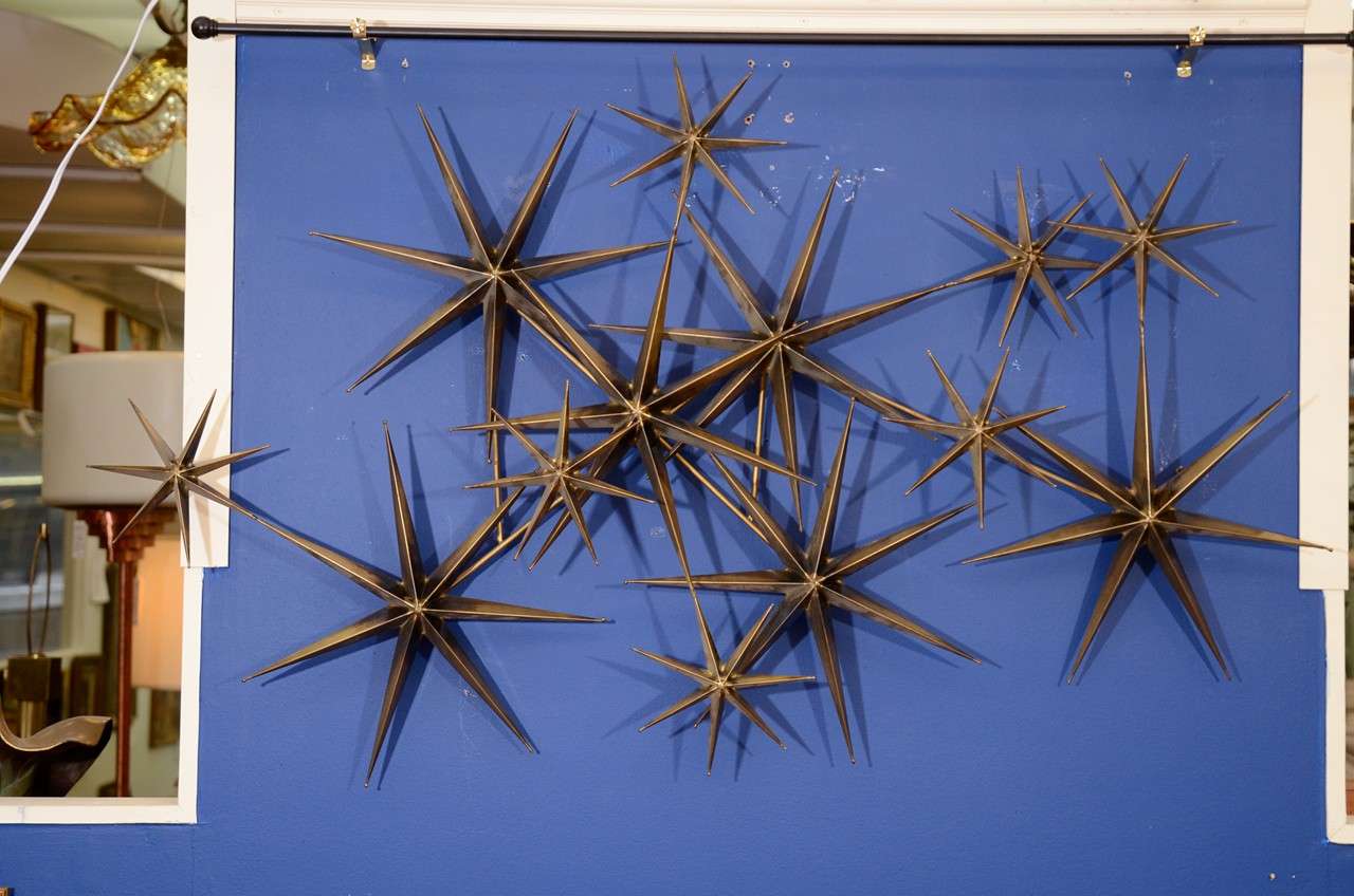 A vintage wall sculpture of abstract metal stars. The piece is signed Curtis Jere, 1981.