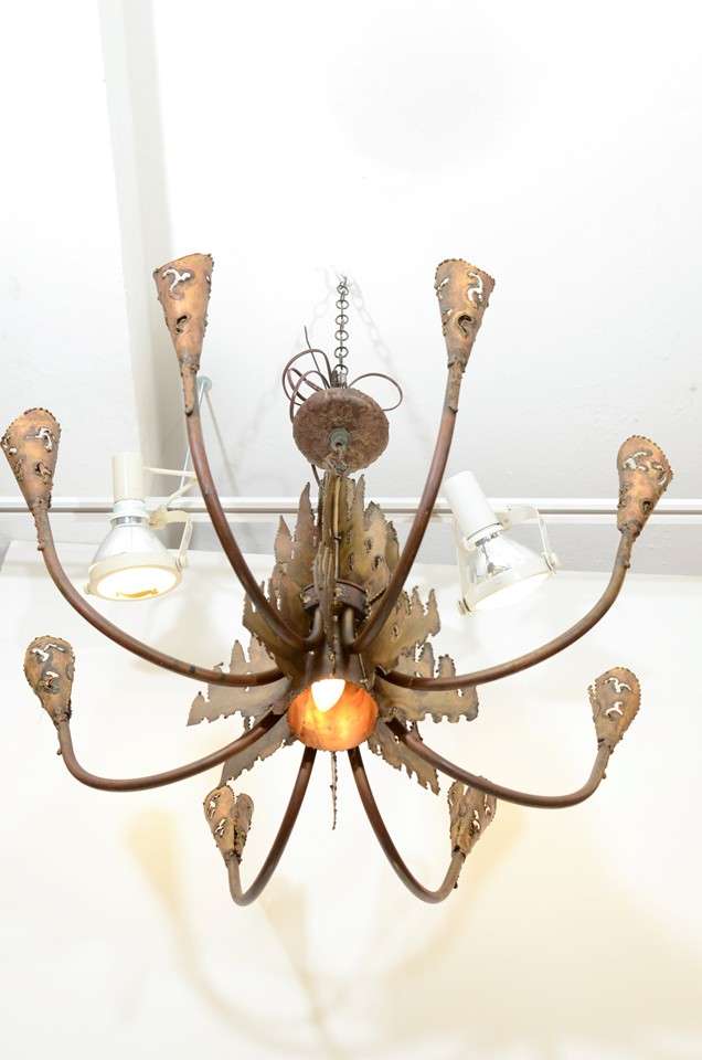 A vintage metal brutalist style chandelier with eight arms and a central light. The piece is by Curtis Jere. It is in good vintage condition with age appropriate patina.
