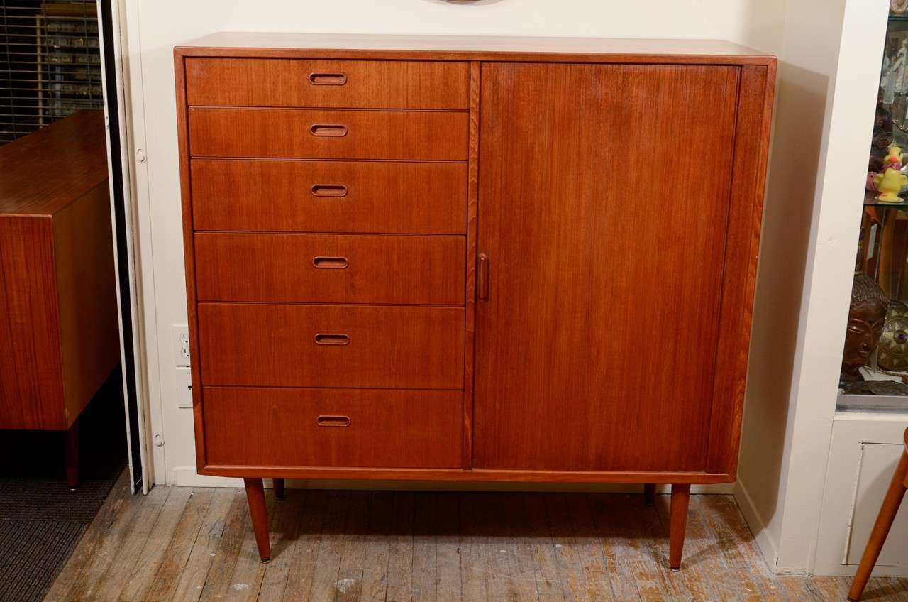 A vintage Scandinavian dresser with six exposed drawers and six additional drawers hidden behind an articulated accordion door.