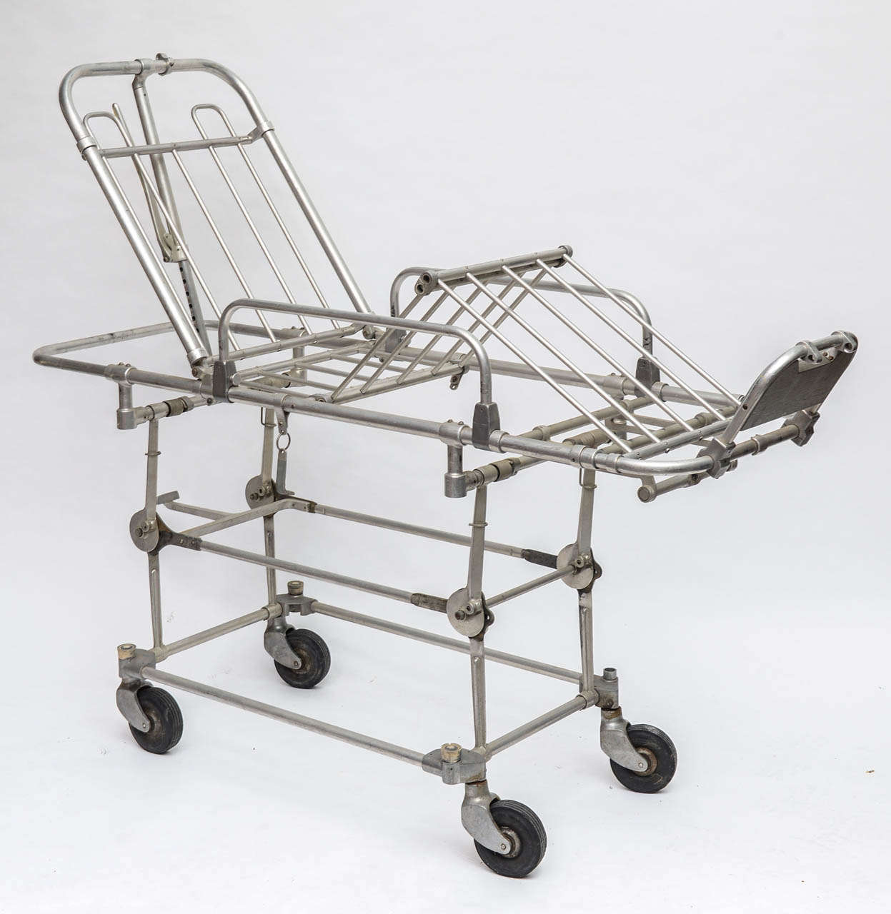 Really cool, vintage industrial hospital gurney. Aluminum frame w/ rubber wheels and original red padding (see additional images which include photo of gurney w/ padding). Fully adjustable. Think outside of the box on this one and add glass shelves