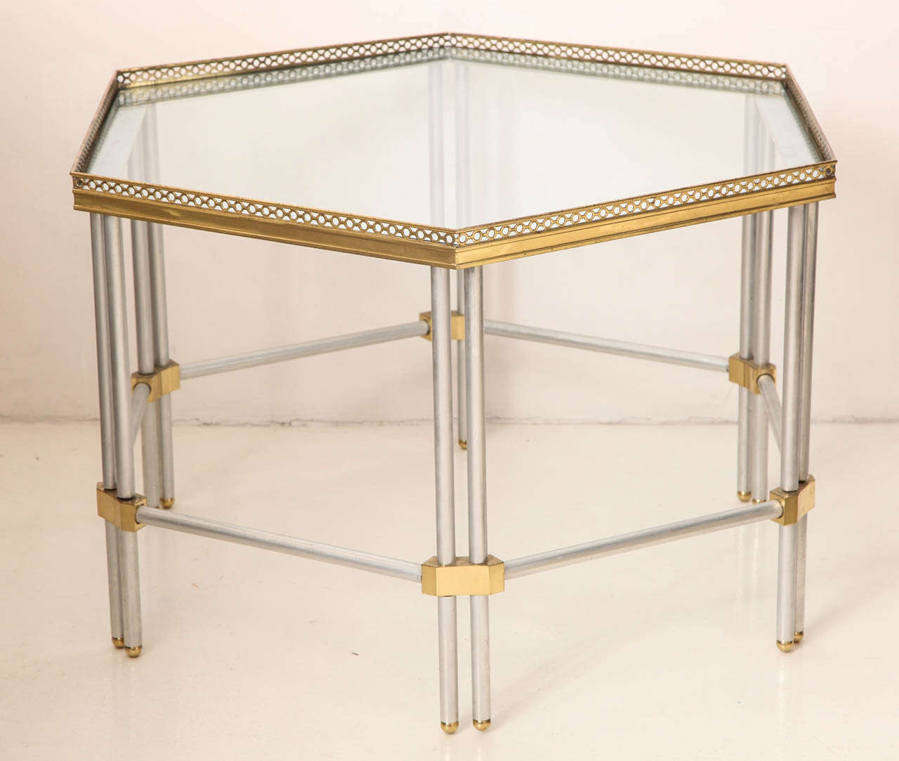 JOHN VESEY (1925-1992)
Hexagonal low table in aluminum with brass accents. 
The glass top is surrounded by a pierced decorative edge. 
American, 1965