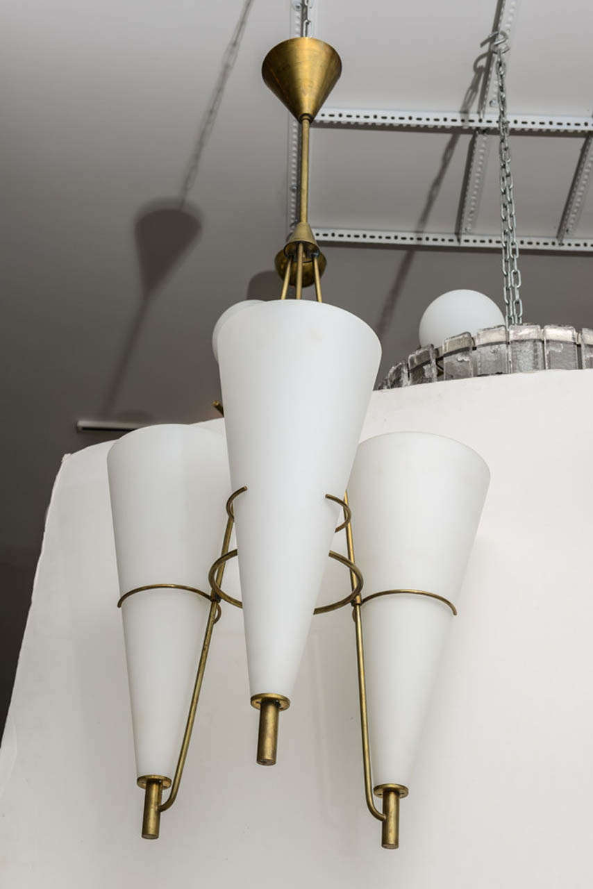 Large frosted glass cone light fixture caged in brass hardware giving a minimalist look attributed to Stilnovo.