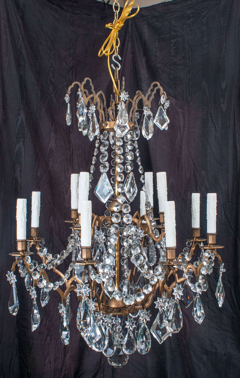 This unique Continental fixture's arms are composed of a series of Gothic and Venetian arches. The crystal prisms, from France, are original to the chandelier and of the highest quality. The fixture is French wired (meaning the wiring is external to