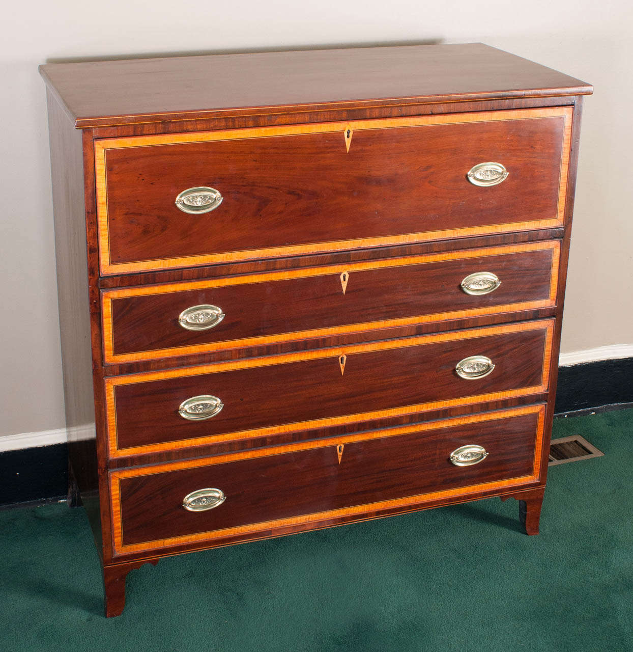 This Hepplewhite piece was probably made in the Mid-Atlantic (Northwestern Virginia or Maryland). It has a beautiful fitted interior pull-out desk section over three graduated chest drawers. The desk has a French Polish which gives a lustrous glow