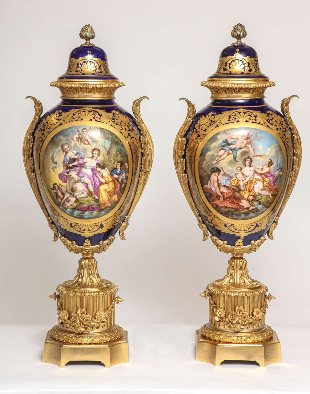 A massive pair of fine antique French ormolu-mounted Sèvres style porcelain covered vases. Each of baluster form, the cover with foliate finial and laurel band, the body finely painted to one side with Europa and the bull and the other painted with