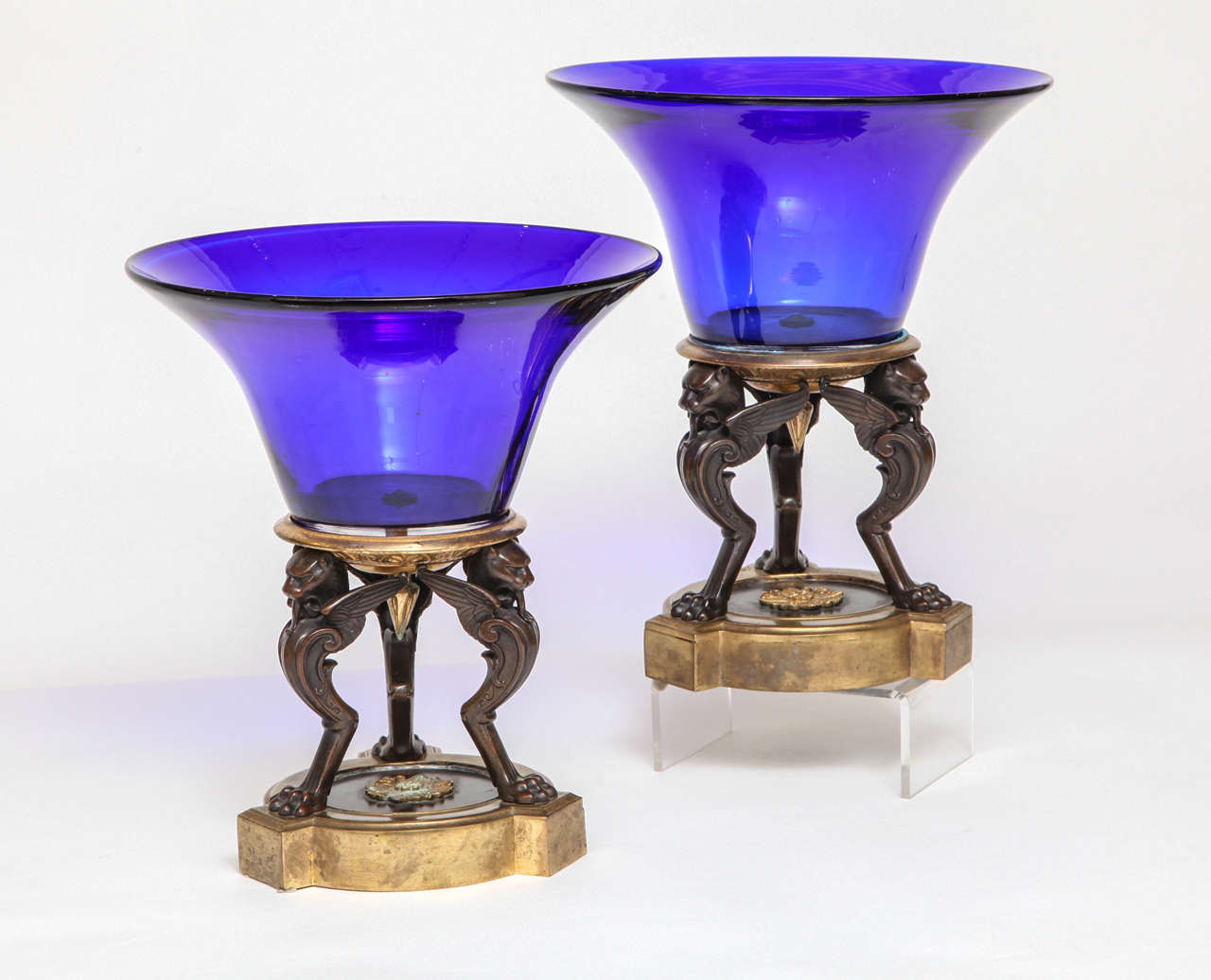 Unusual pair of Antique Russian Empire cobalt blue glass and bronze mounted griffin support centerpieces, the bronze Griffins patinated with gilt bronze bases and accents, mid 1800's