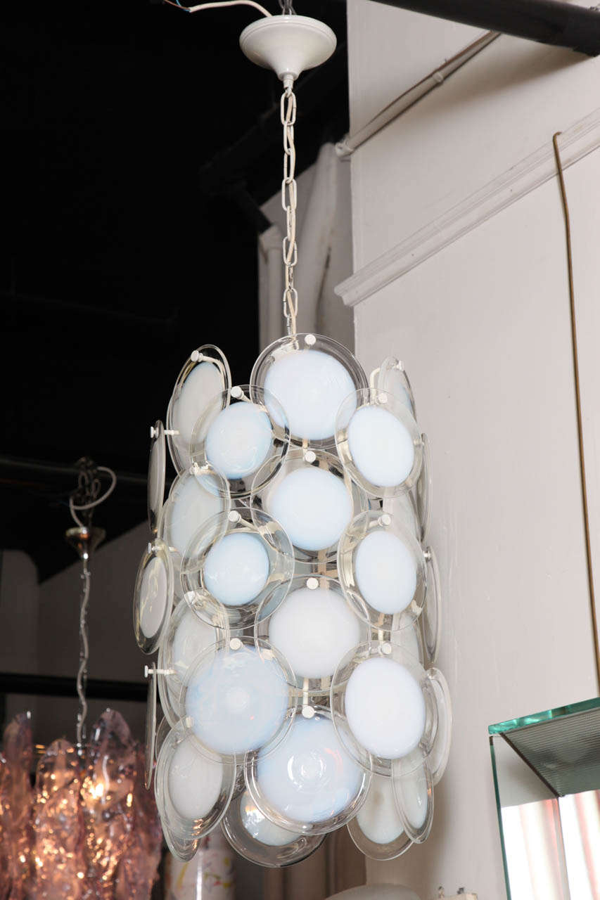Wonderful long chandelier made in Venice, 1965 by Mazzega. Designed by Carlo Nason. All original with white and clear blown glass disks. Very unusual form.
  