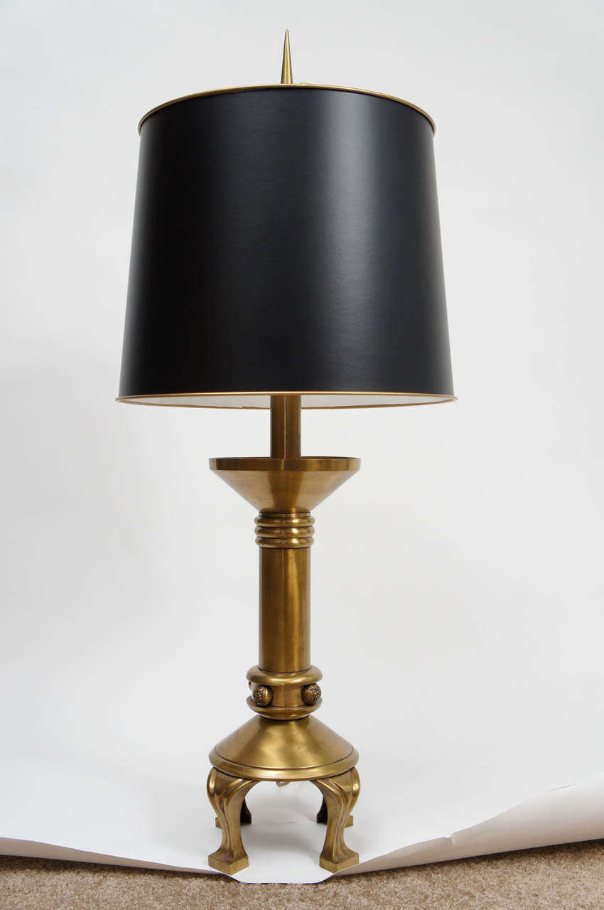 Stunning pair of 1970's brass lamps with new shades, which are black with gold trim.The lamps sit on raised feet, providing an airy yet substantive feeling. The finials are cone shaped and wonderful.