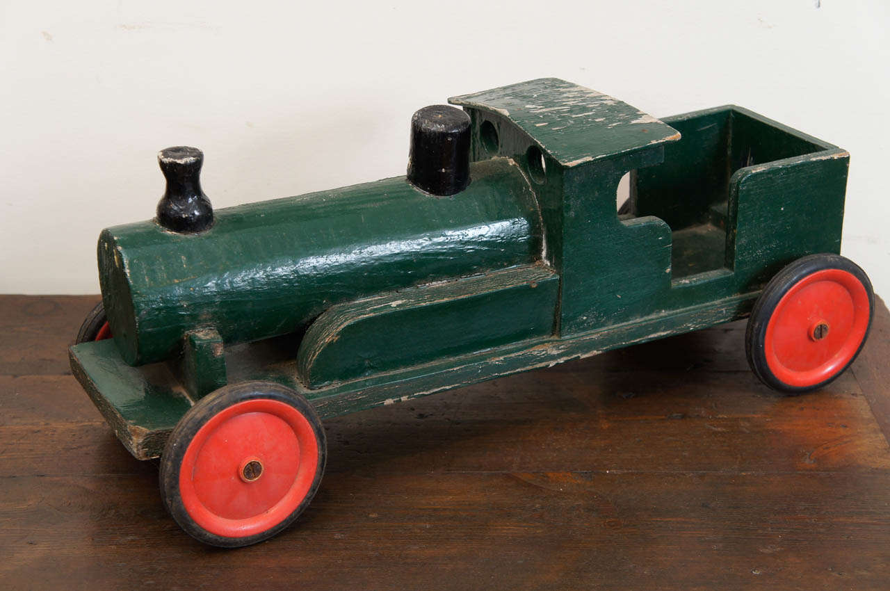 This is part of a much larger collection of children's toys at Painted Porch. We love toy trains and have at least 4-5 others. please ask us. This one is painted a forest green color with 2 black chimney smoke stacks and red wheels . its in very