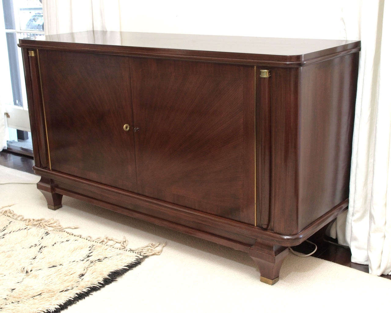 Mahogany two-door cabinet with starburst marquetry at the front door panels; interior with adjustable shelves in sycamore; working key