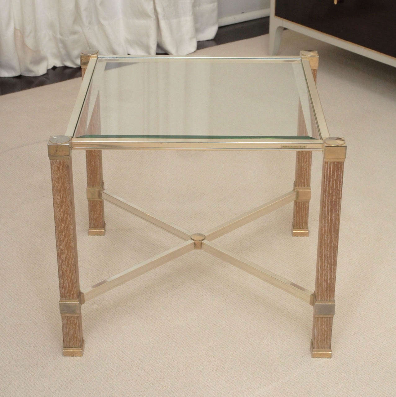 Two square side tables with oak ceruse legs and brass plated details by Pierre Vandel, Paris; so marked; each with beveled glass plateau