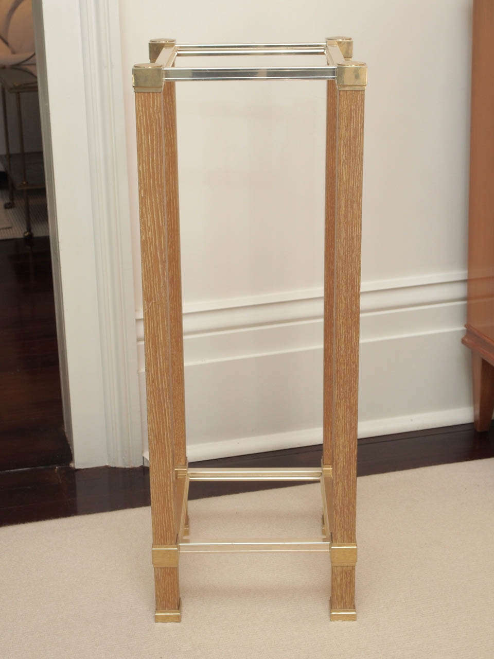 Square two-tier pedestal with legs in oak ceruse; details and stretchers in brass-plated metal; clear glass shelves