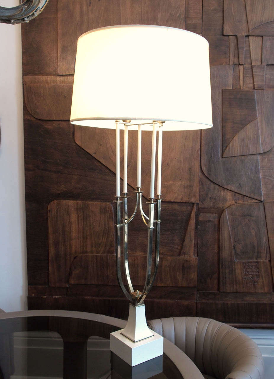 Elegant and quite large 4-light table lamp in the style of Tommi Parzinger; the base and "candles" in ivory-painted wood; upcurving brass supports; shade not included; base measures 5.75" square