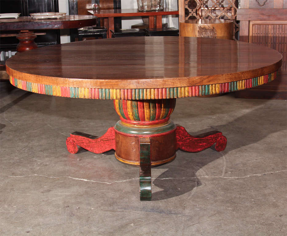Exceptionally large antique table from the island of Bali, Indonesia. Of circular form, the table with 2” thick teak tabletop with carved apron supported on conformingly shaped pedestal base with three shaped leg supports. The apron and base with