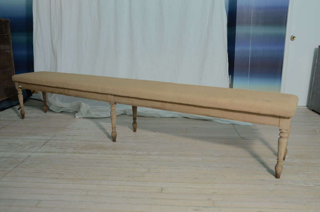 Vintage Swedish extra long bench upholstered in burlap linen with six wooden spindle legs.