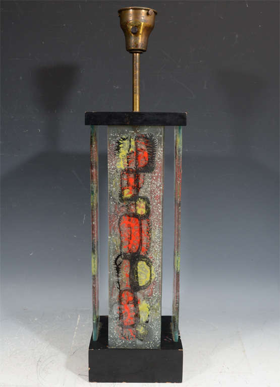 This rare Mid-Century Modern table lamp's body is made of glass panels designed by Michael and Frances Higgins and it sits on a ebonized wood base.

 