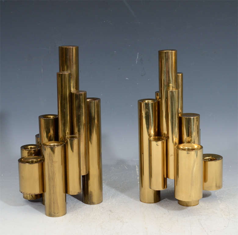 A pair of grouped multi-tiered tubular brass candle holders by Gio Ponti.