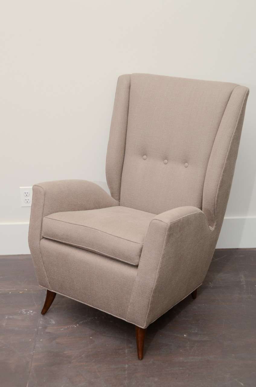 Newly Upholstered Lounge Chair with wooden sabre legs, newly upholstered in a beige linen - original button tufting. 

