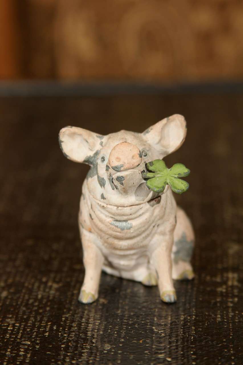 charming little metal pig with 4 leaf clover in his mouth .   top lifts to hide a small treasure .