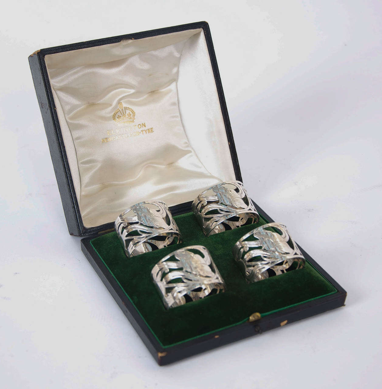 This is a lovely set of 4 sterling silver napkin rings pierced with a sinuous Art Nouveau floral design. The rings were made by the leading British silversmiths Elkington & Co and are hallmarked for Birmingham 1902. They are cased in their original