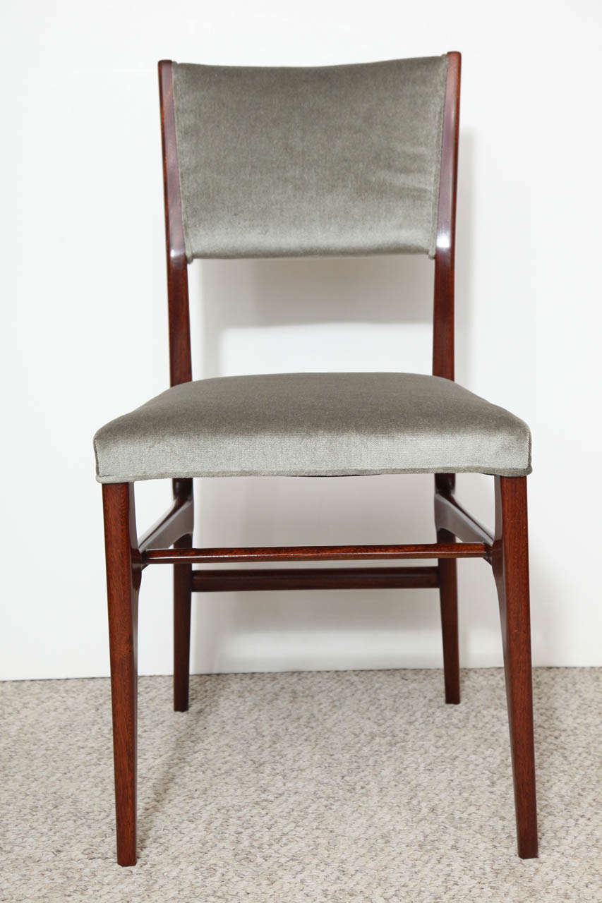Iconic dining chairs by Gio Ponti.  Walnut frames with tapering legs, and uphostered seats and backs.