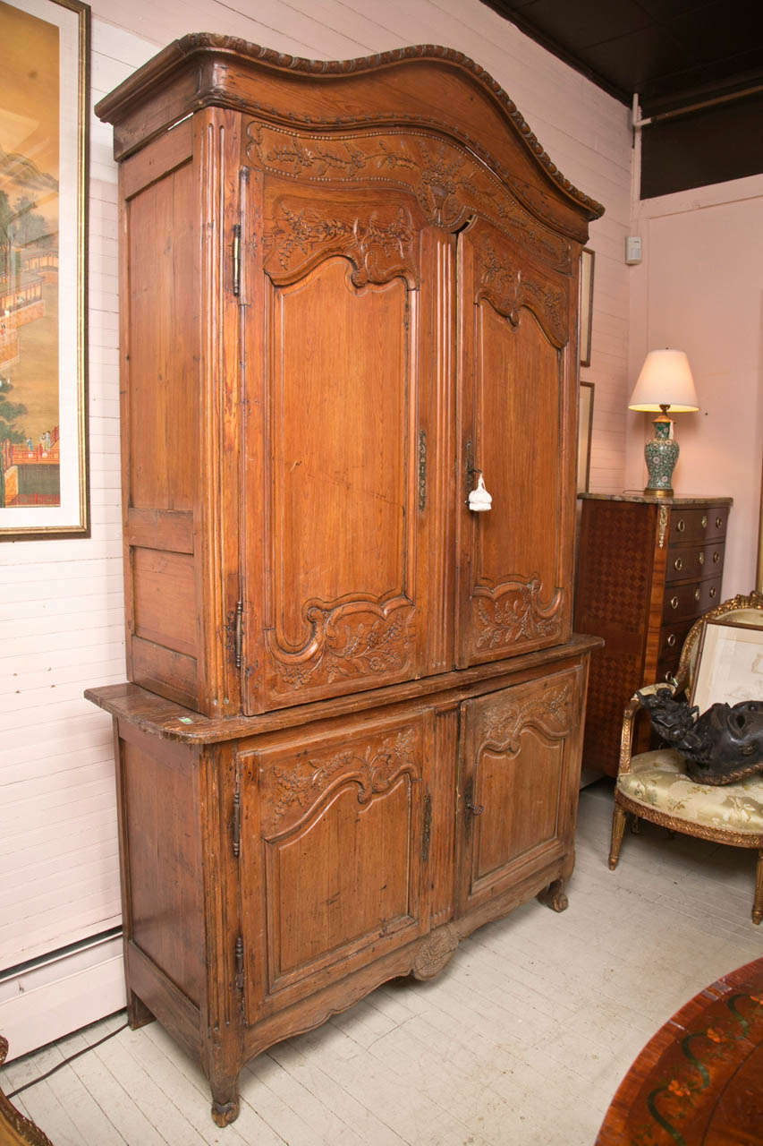 Beautifully carved with arched  bonnet top, separate piece, double doors atop and below  with their original hardware and  locks. The interior painted yellow with a  fitted in (removable)  flip out writing surface in the top section, and a stereo