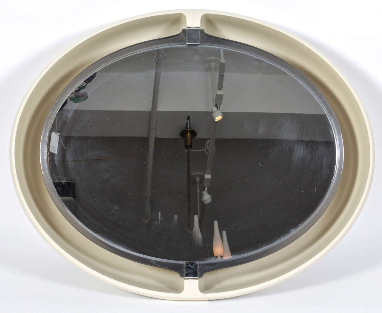 An oval pivoting and lighted wall mirror framed in off-white resin with chrome detailing by Allibert.  France, circa 1970.  May be hung vertically or horizontally.  Photo of interior courtesy of Robert Stilin and Elle Decor.

Dimensions of interior