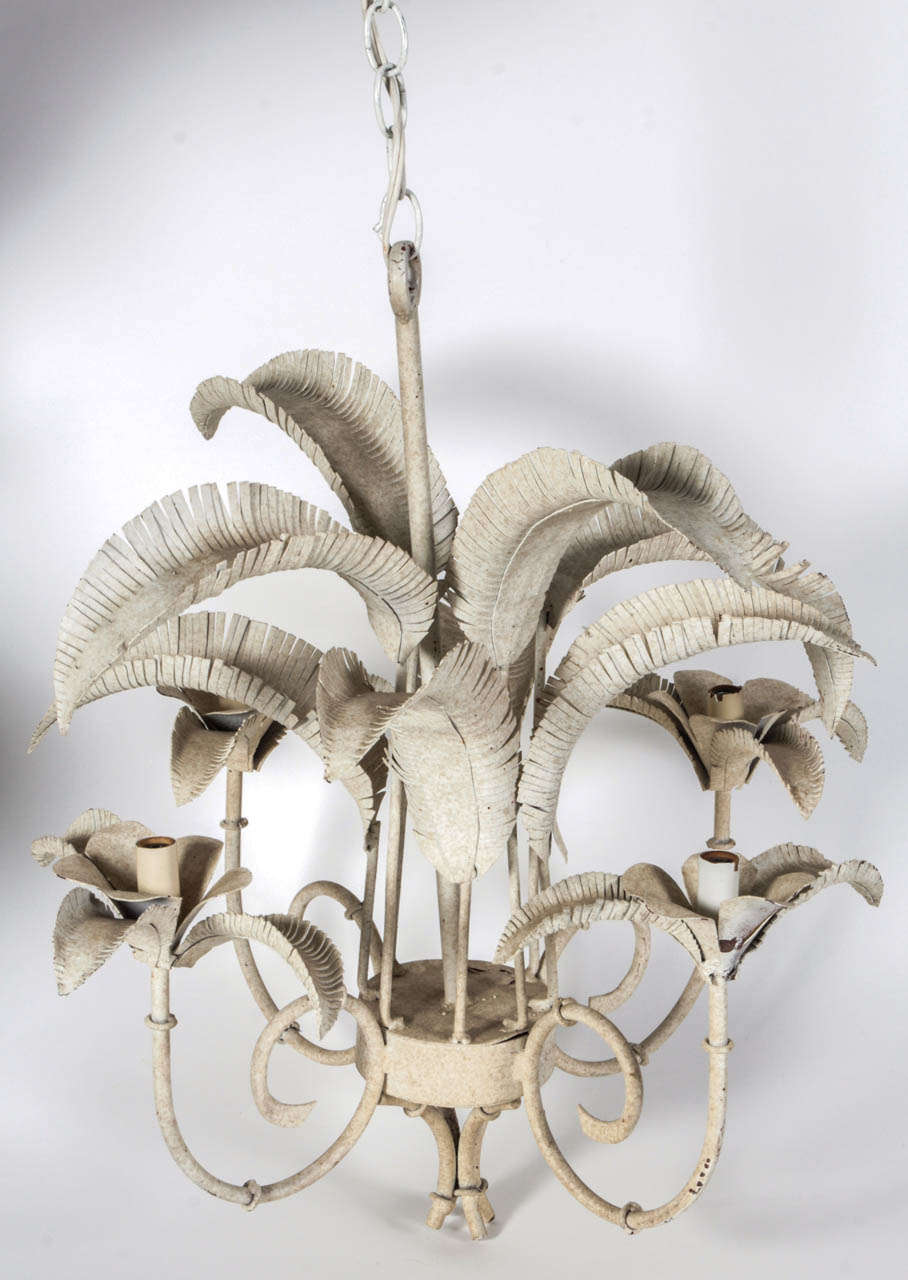 A graceful painted-tole, palm-frond chandelier with four arms.  Original off-white finish.  USA, circa 1960.  Wired for U.S.; takes four chandelier base bulbs, 60 watts max.  Includes fixed hanging stem and also adjustable hanging chain. 