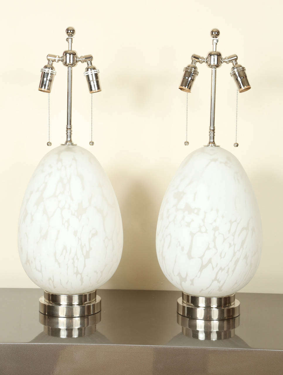 Pair of beautiful Italian glass lamps. The bases are egg shaped translucent glass embedded with white swirls. They have been newly rewired and provided with nickel bases and double cluster hardware