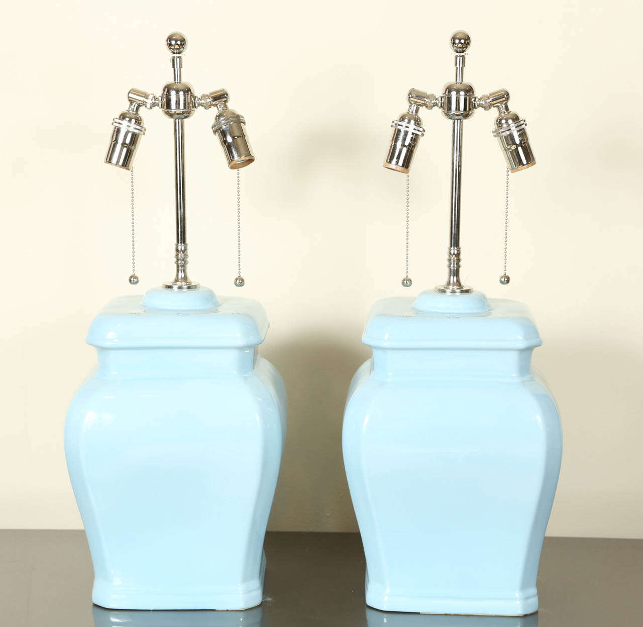 Pair of very pretty squared urn lamps in a lovely powder blue glazed ceramic finish.  The lamps have been newly rewired and fitted with polished nickel double clusters.