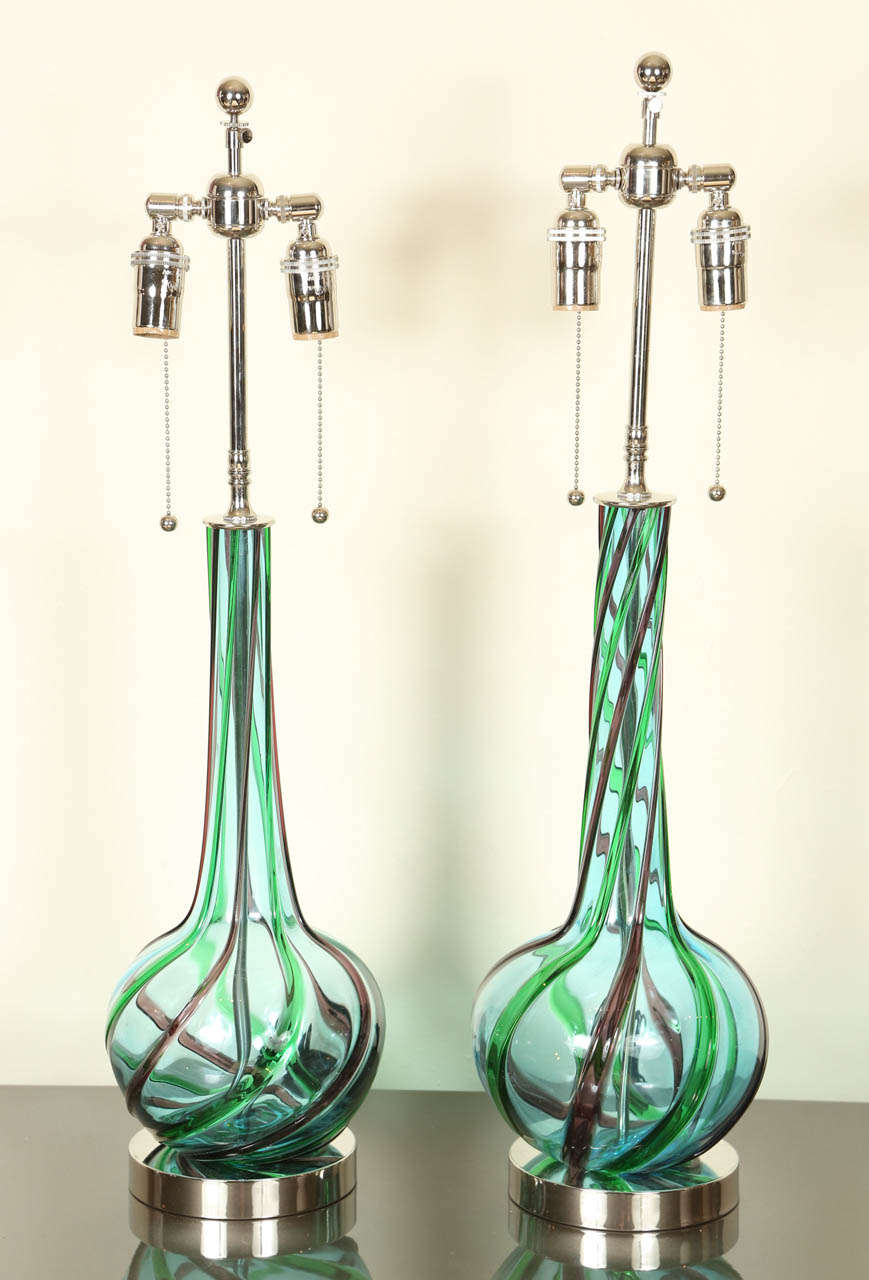 Beautiful pair of Murano lamps in blue with swirled ribbons of green and amethyst. The lamps have been newly rewired and are mounted on polished nickel bases and have nickel double clusters.