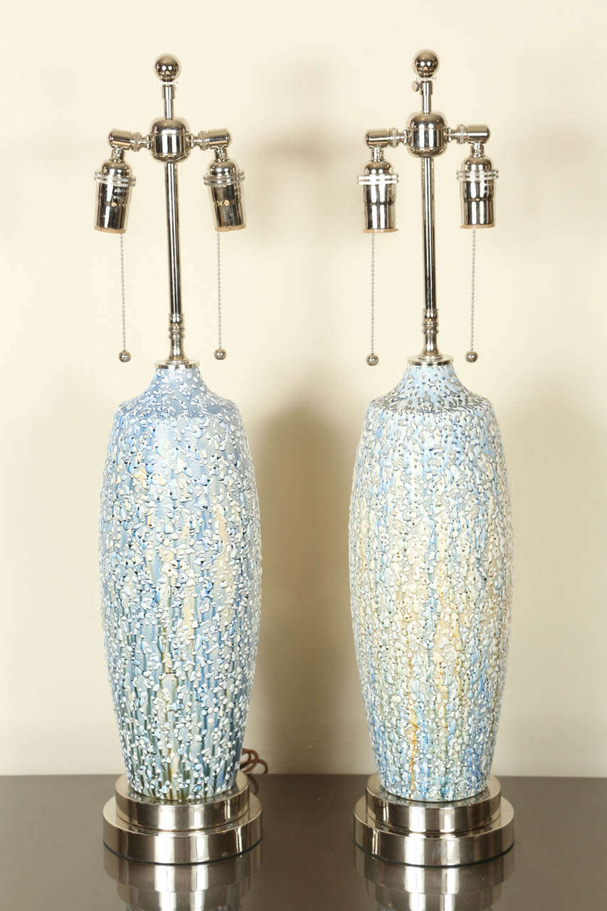 Lovely pair of ceramic lamps with a textured multicolored Volcanic glaze.
The lamps have been newly rewired and outfitted with polished nickel hardware and double clusters and are mounted on nickel bases.